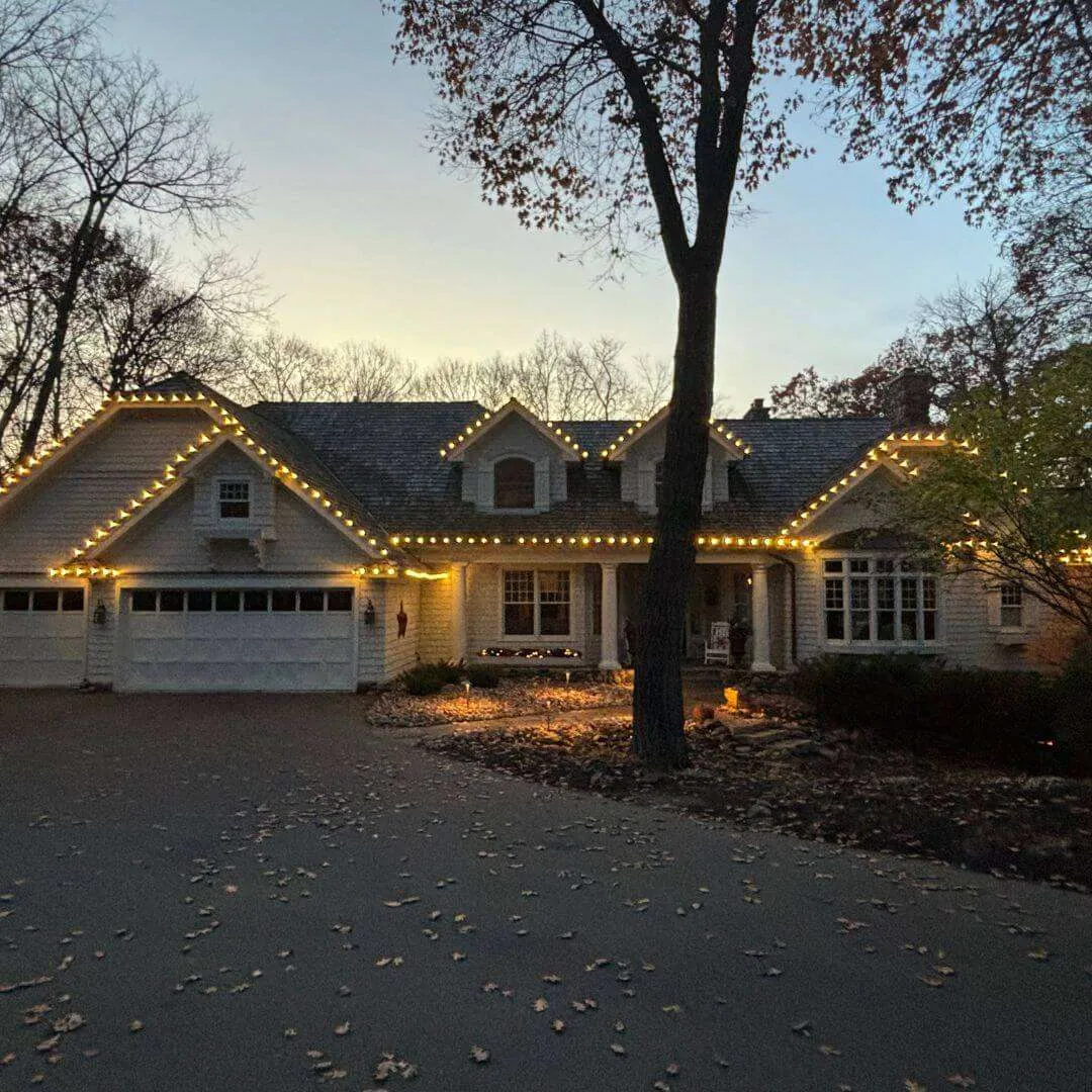 Completed permanent LED roofline system on a West Michigan home, lit warm white